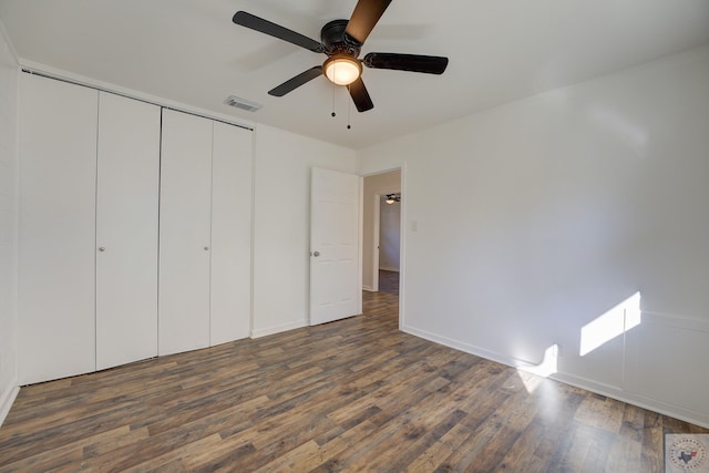 unfurnished bedroom featuring ceiling fan, dark hardwood / wood-style flooring, and a closet