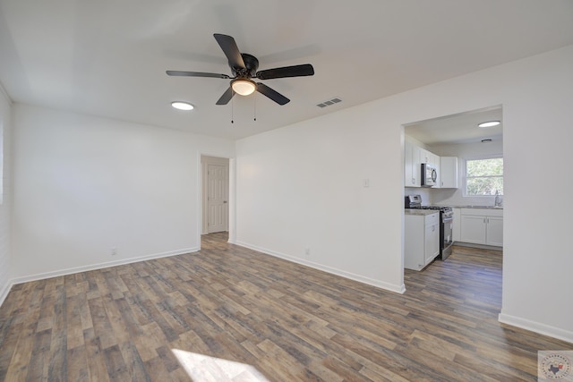 empty room featuring sink, dark wood-type flooring, and ceiling fan