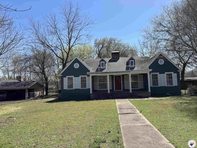 1100 W Jackson St, Clarksville, TX 75426 - view of front of house featuring a chimney, a front lawn, a shingled roof, and covered porch