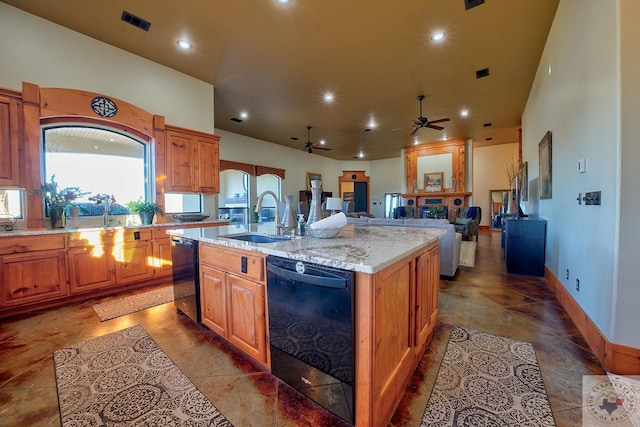 kitchen featuring sink, dishwasher, light stone counters, and a center island with sink