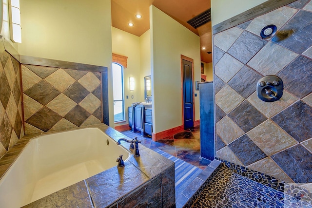 bathroom with vanity and a relaxing tiled tub