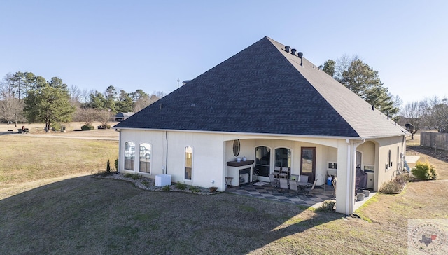 back of house with a patio area and a lawn