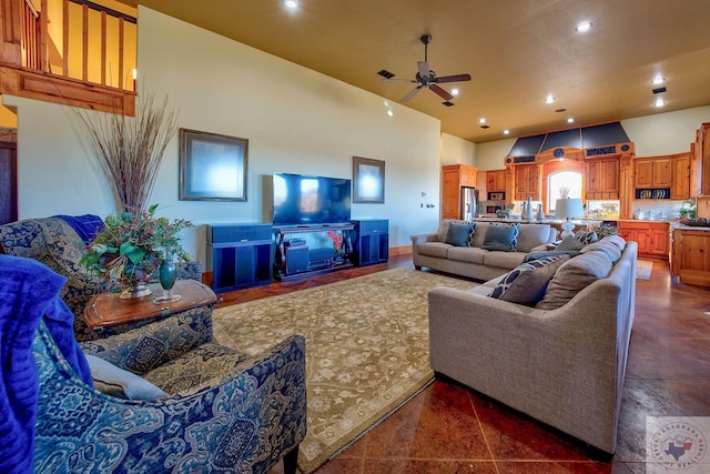 living room with dark tile patterned flooring, a towering ceiling, and ceiling fan