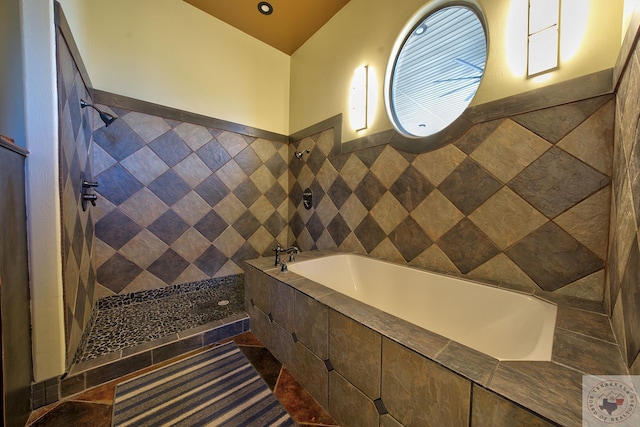 bathroom with separate shower and tub and tile walls