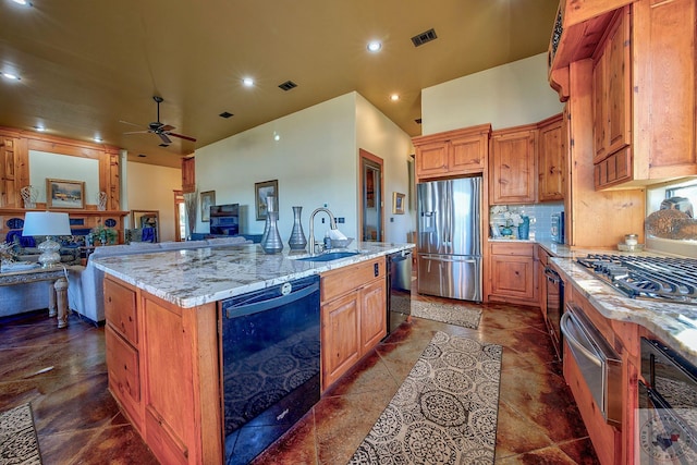 kitchen featuring light stone countertops, tasteful backsplash, a kitchen island with sink, sink, and stainless steel appliances