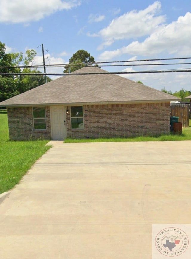 ranch-style home featuring a front lawn