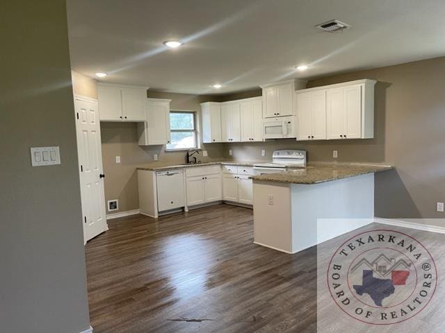 kitchen featuring white appliances, dark wood-type flooring, white cabinetry, dark stone countertops, and sink