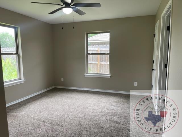 unfurnished room featuring ceiling fan and carpet