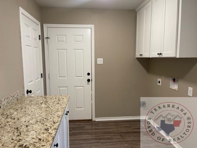 clothes washing area with hookup for an electric dryer, cabinets, hookup for a washing machine, and dark hardwood / wood-style flooring