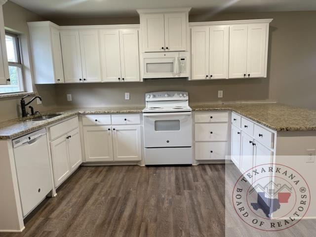 kitchen with light stone countertops, sink, white appliances, and white cabinets