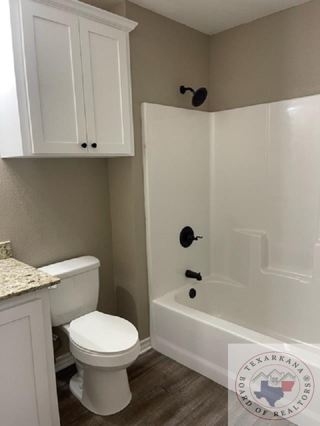 full bathroom featuring tub / shower combination, hardwood / wood-style floors, toilet, and vanity