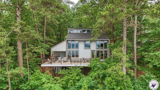 10 Jetty Steel Dr, Murfreesboro, AR 71958 - rear view of property featuring a wooden deck, a view of trees, and roof with shingles