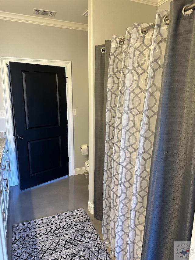 bathroom featuring toilet and ornamental molding