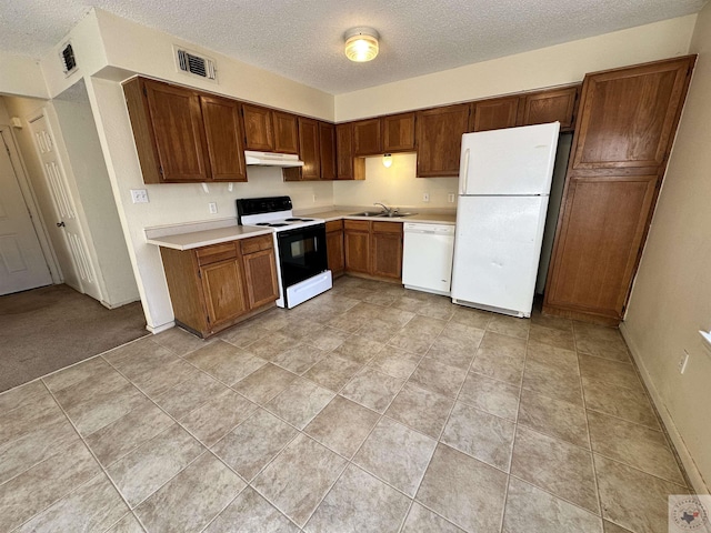 kitchen with sink, a textured ceiling, and white appliances