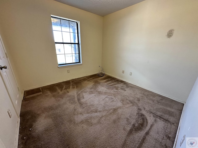 carpeted spare room featuring a textured ceiling