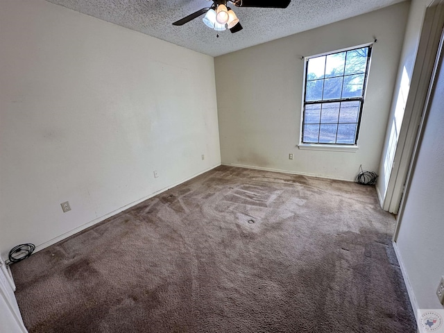 carpeted empty room featuring ceiling fan and a textured ceiling