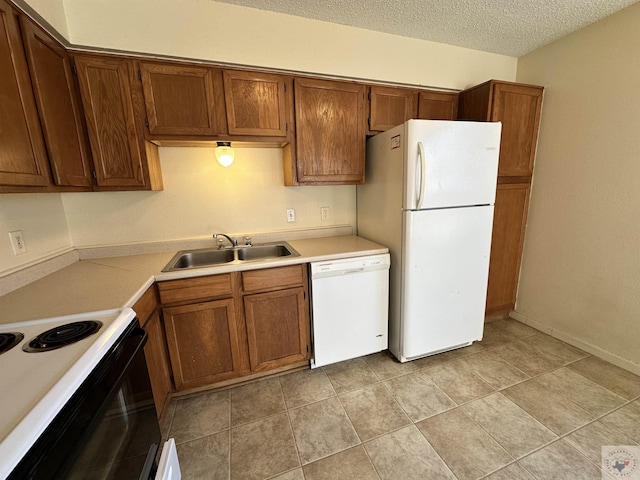 kitchen with sink, white appliances, and a textured ceiling