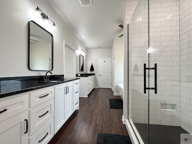375 Fm 2149, New Boston, TX 75570 - bathroom with wood finished floors, two vanities, a sink, a freestanding bath, and a shower stall