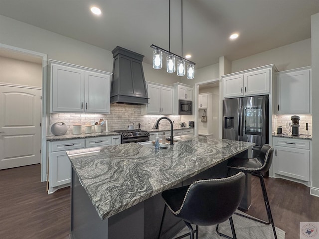 375 Fm 2149, New Boston, TX 75570 - kitchen with premium range hood, a sink, a kitchen breakfast bar, appliances with stainless steel finishes, and light stone countertops