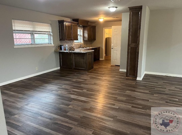 kitchen with dark hardwood / wood-style floors, dark brown cabinetry, and decorative backsplash