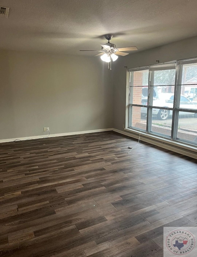 unfurnished room with ceiling fan, plenty of natural light, dark hardwood / wood-style floors, and a textured ceiling