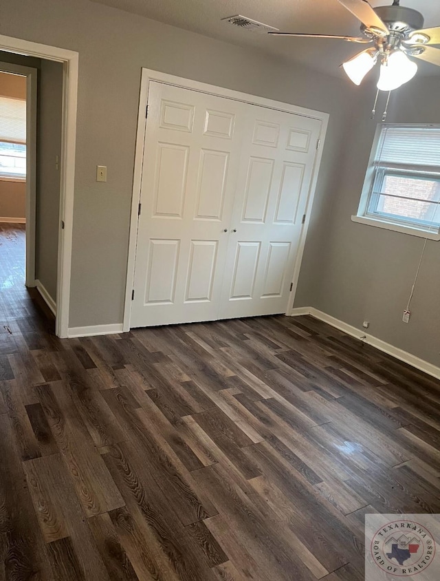 unfurnished bedroom featuring dark hardwood / wood-style flooring, a closet, and ceiling fan