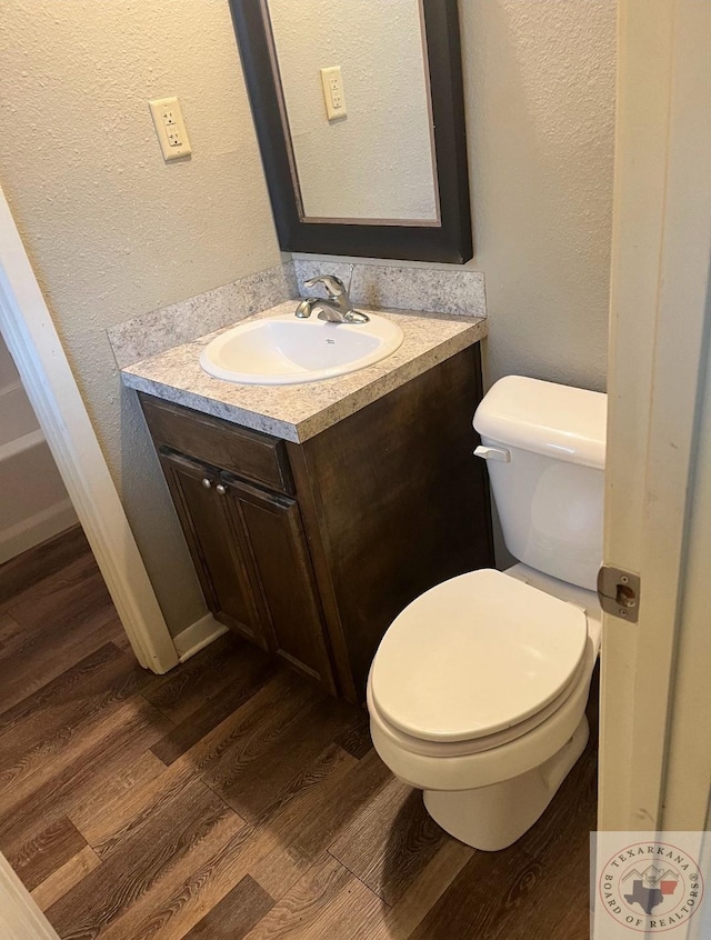 bathroom with hardwood / wood-style flooring, vanity, and toilet