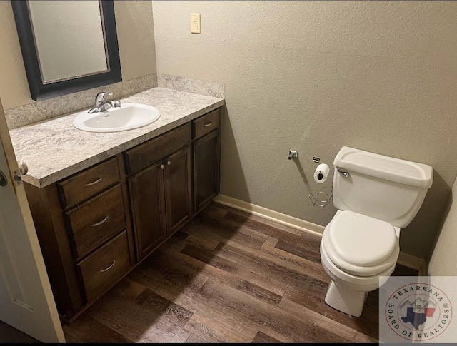 bathroom with vanity, toilet, and hardwood / wood-style floors