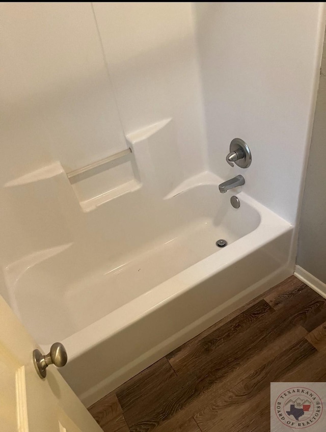 bathroom with wood-type flooring and shower / bath combination