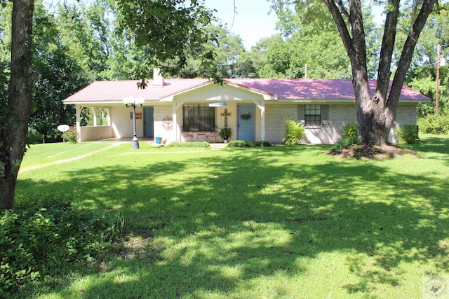 ranch-style house featuring a chimney, a front lawn, and brick siding