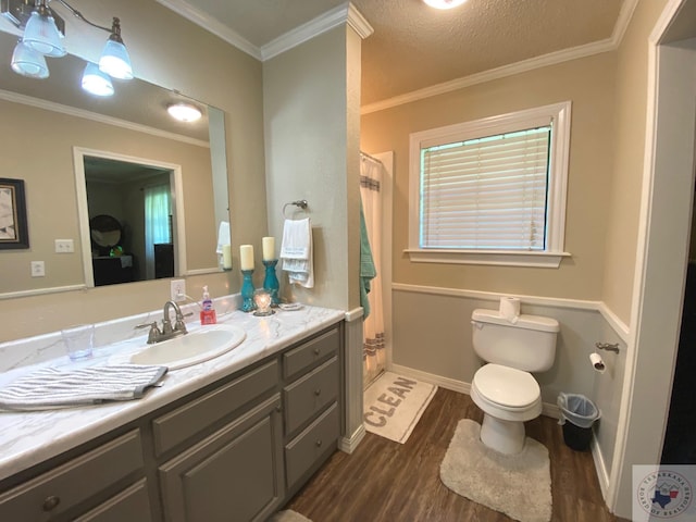 bathroom with crown molding, a shower with shower curtain, toilet, vanity, and wood finished floors