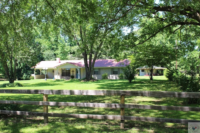 single story home with a chimney, a front yard, and fence