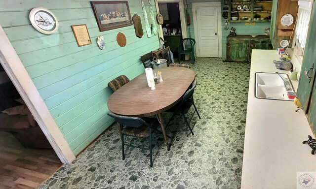 dining area featuring sink and wood walls