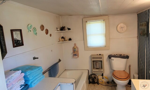 bathroom featuring toilet, heating unit, a bathing tub, and vanity