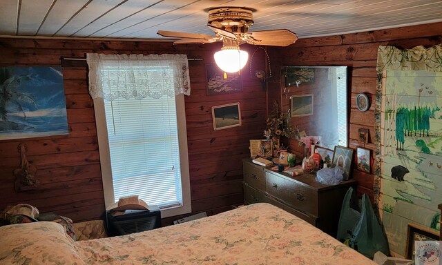 bedroom featuring wood walls, wooden ceiling, and ceiling fan