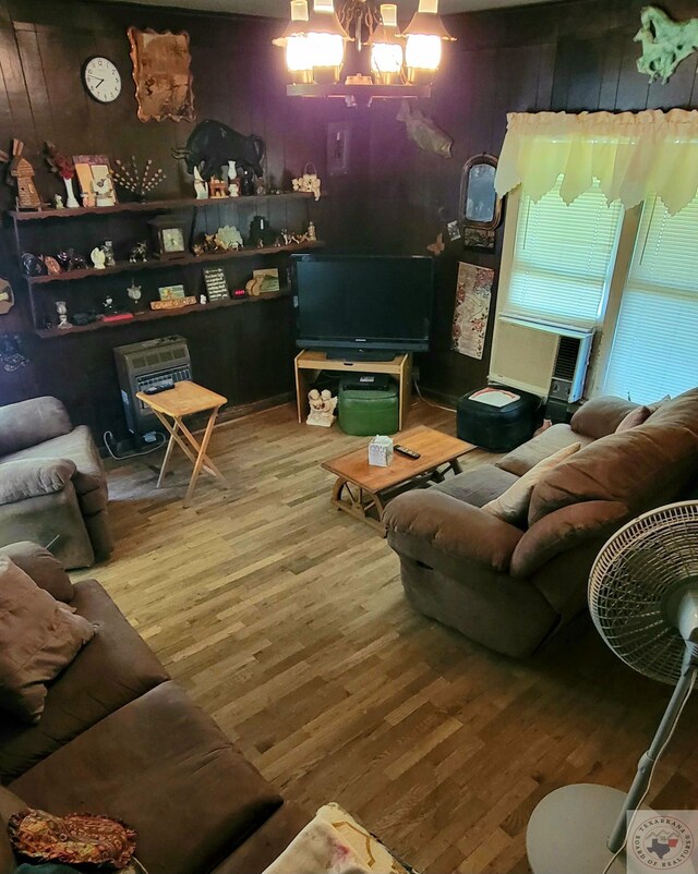 living room featuring cooling unit, a chandelier, and wood-type flooring