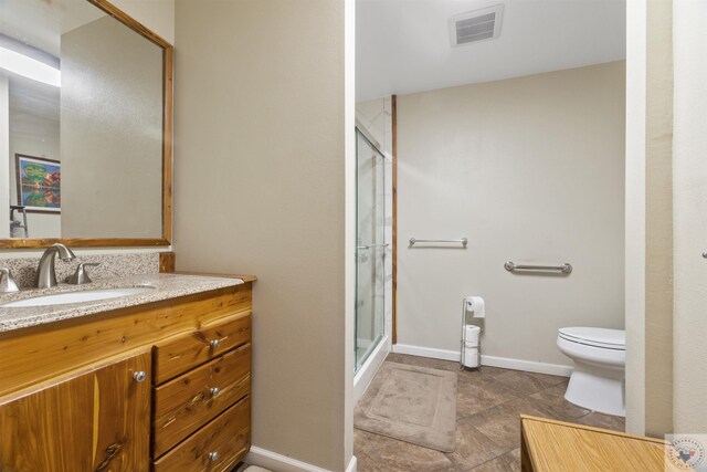 bathroom with vanity, toilet, and a shower with door