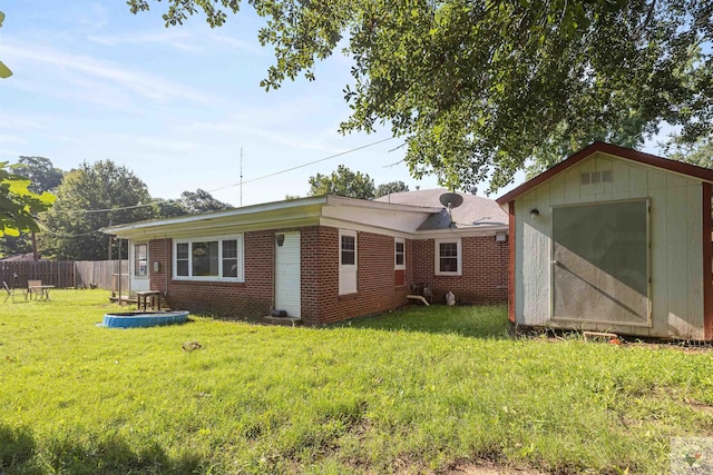 rear view of house with a lawn and a storage shed