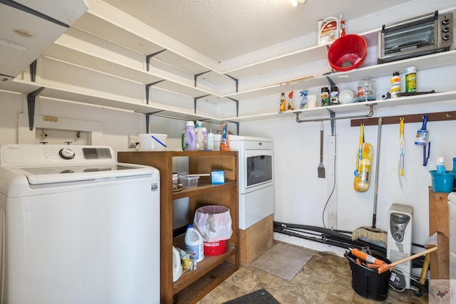 clothes washing area featuring washer / clothes dryer and a textured ceiling