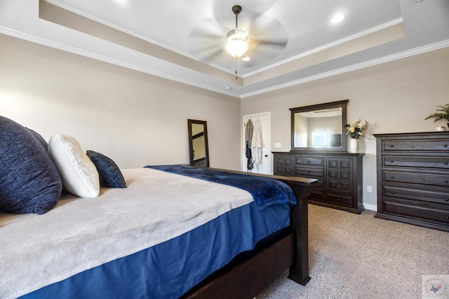 bedroom featuring ceiling fan, light carpet, a tray ceiling, and crown molding