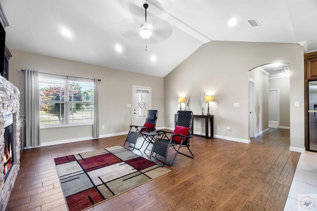 living room featuring a fireplace, dark wood-type flooring, ceiling fan, and lofted ceiling