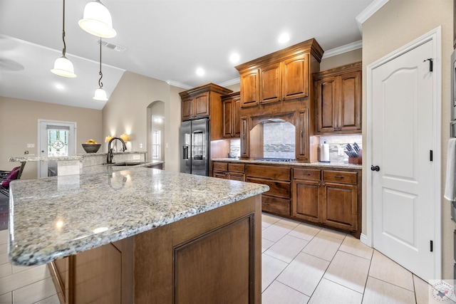 kitchen with decorative light fixtures, stainless steel appliances, sink, backsplash, and a large island