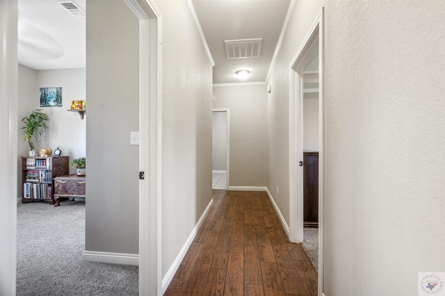 hall with wood-type flooring and ornamental molding