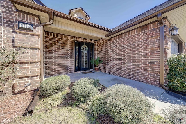 view of exterior entry with brick siding