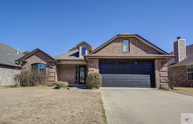 view of front of house with brick siding, concrete driveway, a standing seam roof, metal roof, and a garage