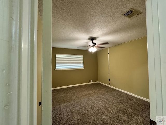 empty room with ceiling fan, carpet, and a textured ceiling