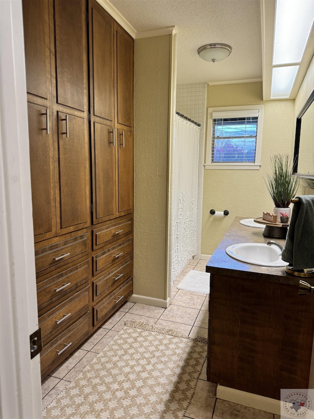 bathroom with curtained shower, a textured ceiling, tile patterned flooring, and vanity