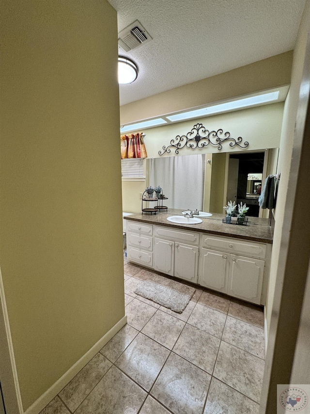 bathroom with vanity, tile patterned floors, and a textured ceiling