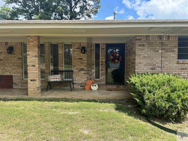 property entrance featuring a patio area and a yard