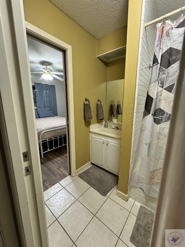 bathroom featuring a textured ceiling, tile patterned flooring, and ceiling fan